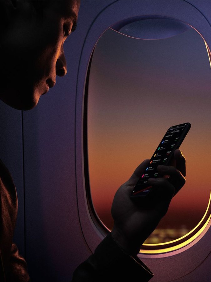 Booking on a phone beside the window at dusk